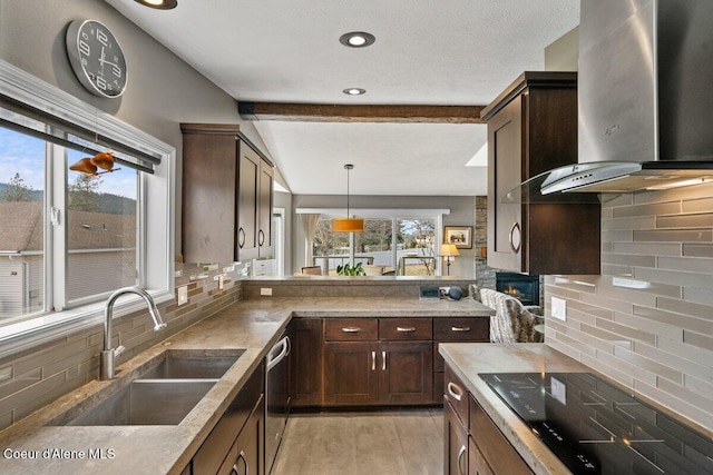 kitchen with dark brown cabinetry, wall chimney exhaust hood, decorative light fixtures, black electric stovetop, and a sink