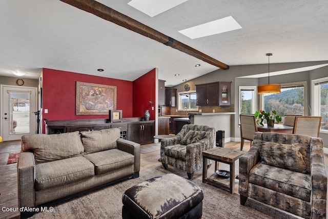 living room featuring vaulted ceiling with skylight and wood finished floors