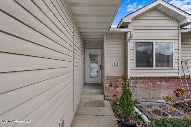 view of exterior entry featuring brick siding