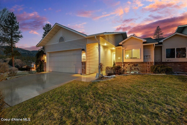 ranch-style house featuring a garage, concrete driveway, brick siding, and a yard