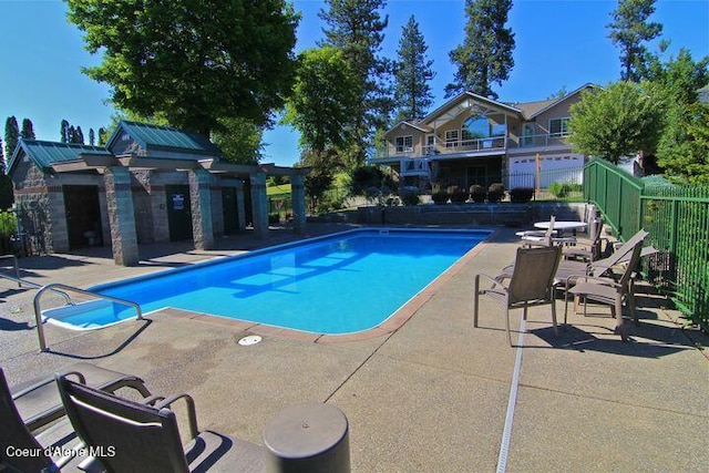 view of swimming pool with an outbuilding, a patio area, fence, and a fenced in pool