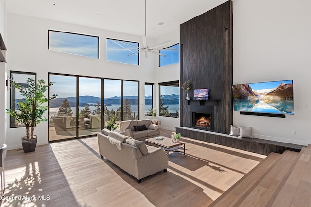 2766 S Helen Dr, Coeur Dalene, ID 83814 - living room with a large fireplace, a towering ceiling, baseboards, and wood finished floors