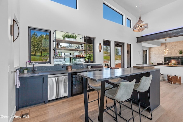 2766 S Helen Dr, Coeur Dalene, ID 83814 - kitchen featuring dark countertops, light wood-style flooring, decorative light fixtures, stainless steel dishwasher, and a sink