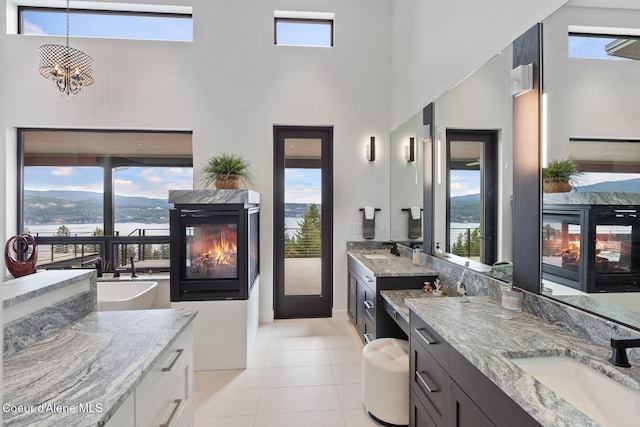 2766 S Helen Dr, Coeur Dalene, ID 83814 - full bathroom featuring tile patterned flooring, a fireplace, two vanities, and a sink