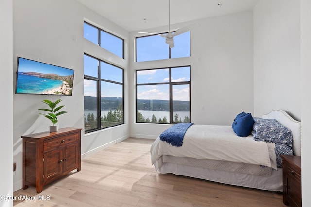 2766 S Helen Dr, Coeur Dalene, ID 83814 - bedroom featuring light wood finished floors, a water view, a high ceiling, and baseboards