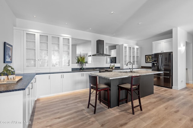 2766 S Helen Dr, Coeur Dalene, ID 83814 - kitchen featuring black fridge with ice dispenser, glass insert cabinets, a kitchen island with sink, a sink, and wall chimney range hood