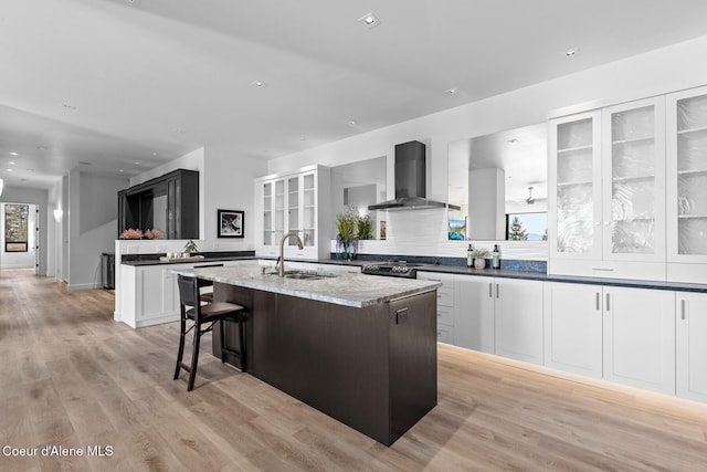 2766 S Helen Dr, Coeur Dalene, ID 83814 - kitchen with a center island with sink, stainless steel electric range oven, light wood-style flooring, a sink, and wall chimney exhaust hood