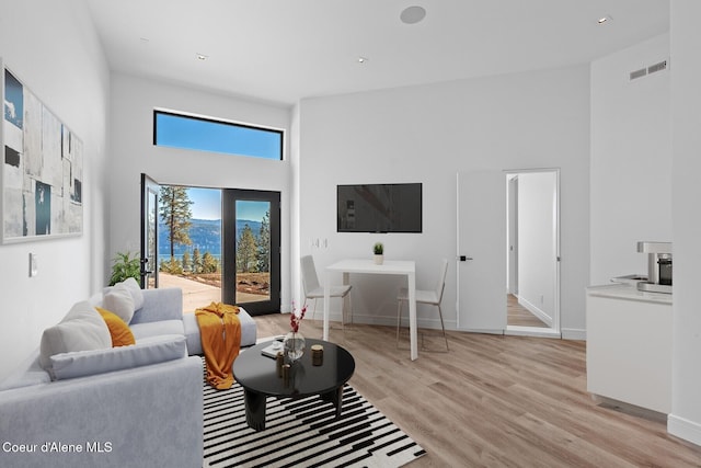 2766 S Helen Dr, Coeur Dalene, ID 83814 - living room with light wood-type flooring, baseboards, a high ceiling, and visible vents