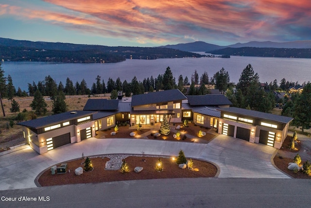 2766 S Helen Dr, Coeur Dalene, ID 83814 - view of front of property with metal roof, an attached garage, curved driveway, a water and mountain view, and a standing seam roof