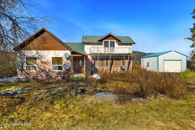 view of front of house featuring an outbuilding, a garage, and metal roof