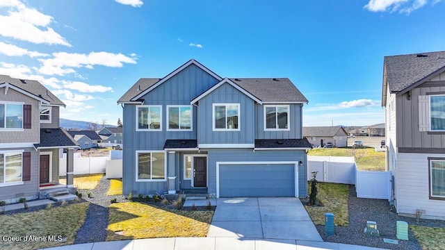 view of front of property with board and batten siding, concrete driveway, fence, and a garage