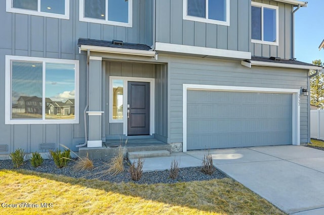 entrance to property with a garage, a shingled roof, concrete driveway, crawl space, and board and batten siding