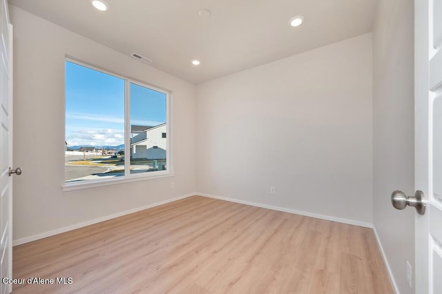 empty room featuring recessed lighting, visible vents, baseboards, and wood finished floors