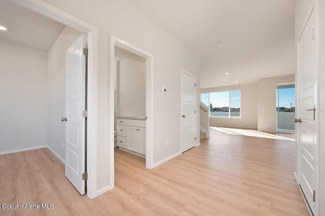 hall featuring light wood-type flooring, stairway, baseboards, and recessed lighting