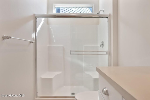 bathroom featuring a stall shower, vanity, and toilet