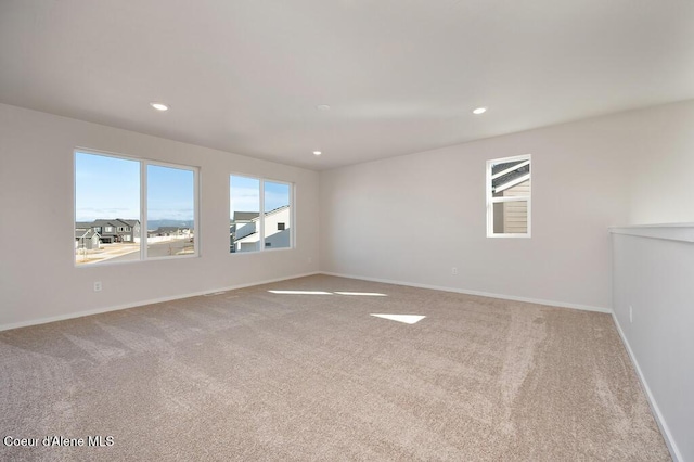 carpeted spare room featuring baseboards and recessed lighting