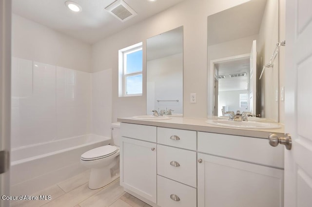 bathroom with visible vents, a sink, toilet, and double vanity