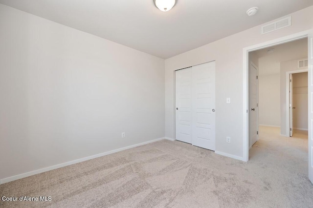 unfurnished bedroom featuring a closet, baseboards, visible vents, and carpet flooring