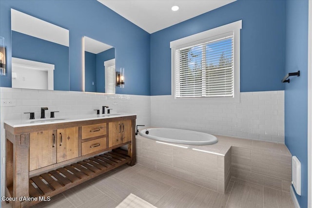 bathroom with tile patterned flooring, a sink, a bath, and double vanity