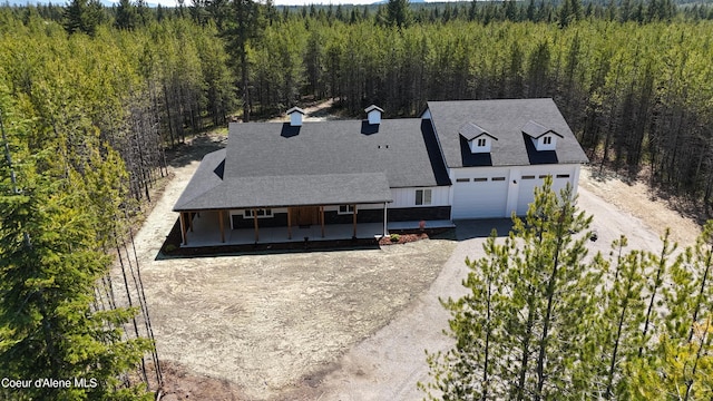 drone / aerial view featuring a wooded view