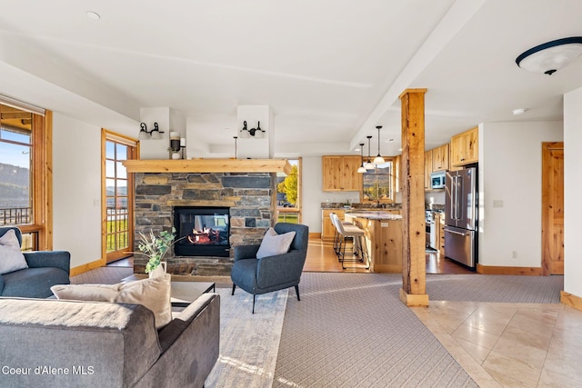 living area featuring a fireplace, baseboards, and light tile patterned flooring