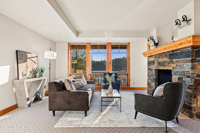 carpeted living area with a fireplace and baseboards