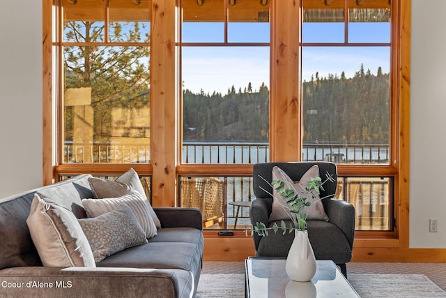 sunroom featuring a water view and a forest view