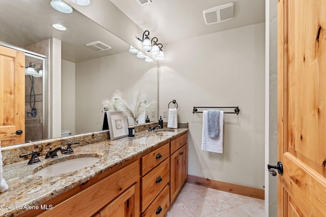 bathroom featuring a stall shower, visible vents, a sink, and tile patterned floors