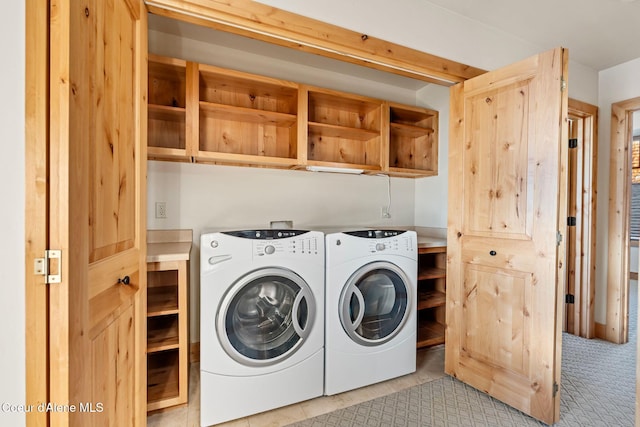 clothes washing area with cabinet space and independent washer and dryer