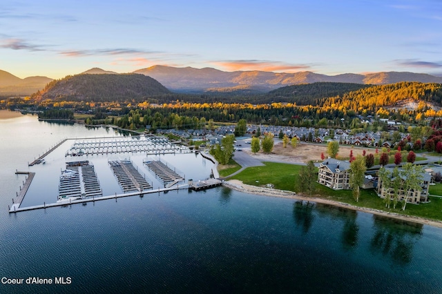 aerial view at dusk featuring a water and mountain view