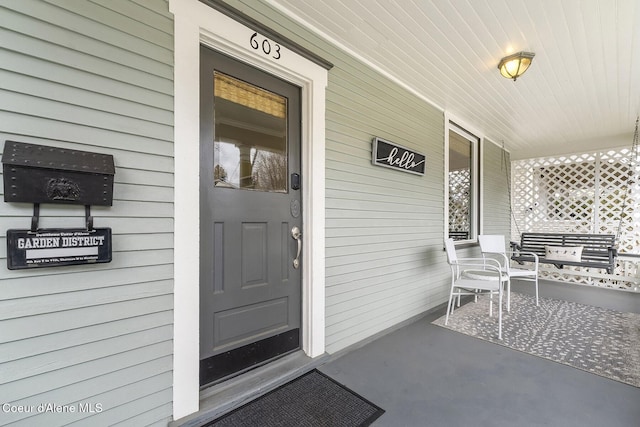 view of exterior entry featuring covered porch