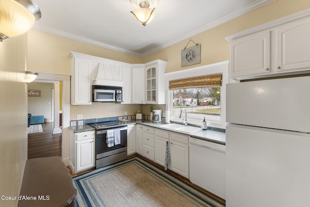 kitchen featuring stainless steel appliances, white cabinetry, a sink, and ornamental molding