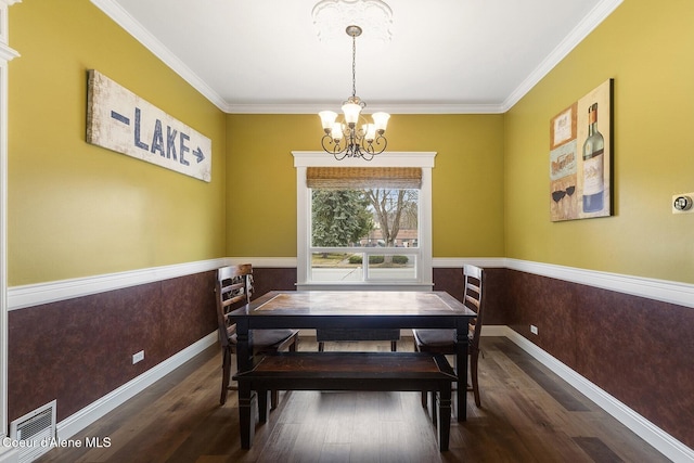 dining room with a chandelier, a wainscoted wall, wood finished floors, and visible vents