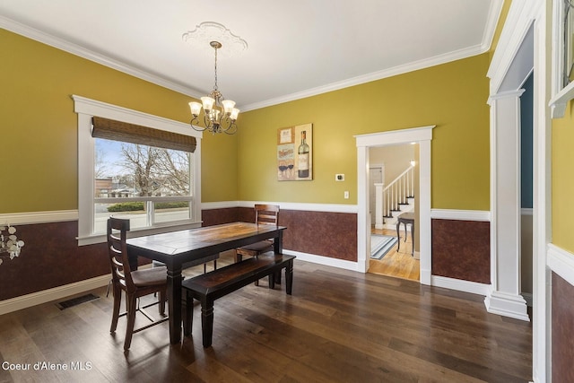 dining space with a chandelier, visible vents, wainscoting, dark wood-style floors, and crown molding