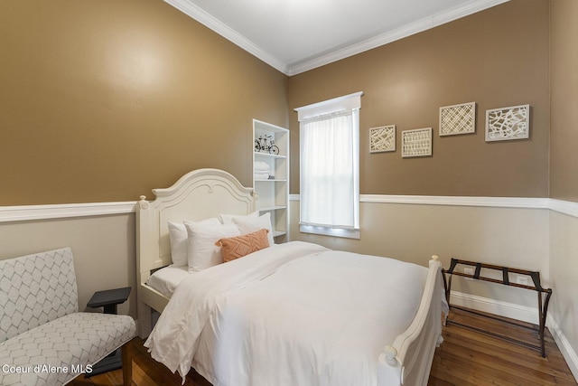 bedroom with ornamental molding, baseboards, and wood finished floors