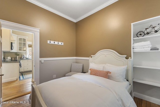 bedroom with ornamental molding and hardwood / wood-style flooring