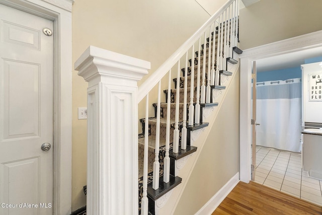 stairway featuring baseboards and wood finished floors