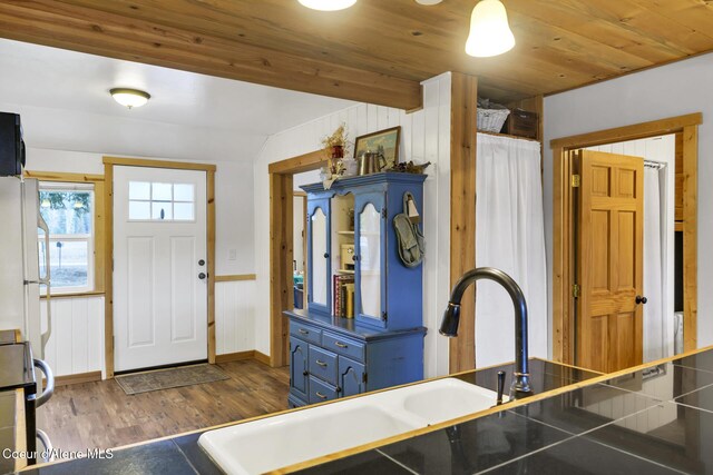 kitchen with dark wood-style flooring, freestanding refrigerator, a sink, black electric range, and wood ceiling