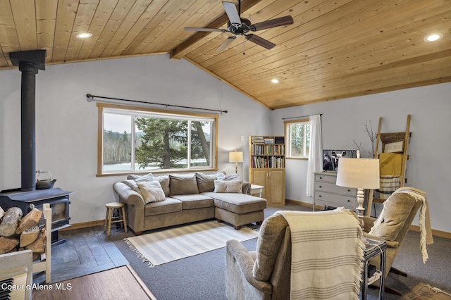 living area with a wood stove, vaulted ceiling with beams, wood ceiling, and a wealth of natural light