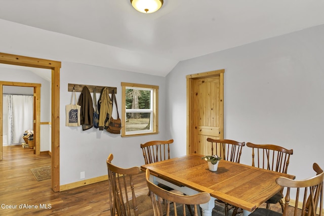 dining area with vaulted ceiling, wood finished floors, and baseboards