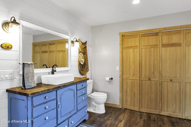 bathroom featuring vanity, toilet, wood finished floors, and a closet