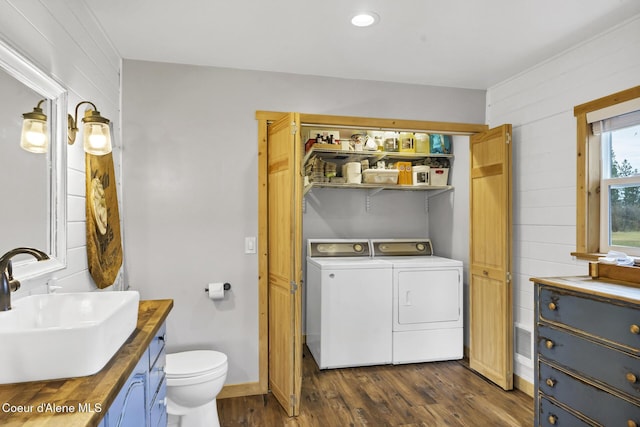 bathroom featuring toilet, independent washer and dryer, wood finished floors, wooden walls, and vanity