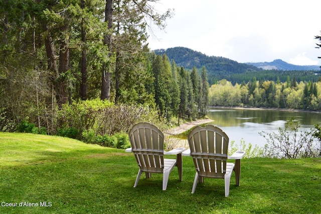 view of yard with a view of trees and a water and mountain view