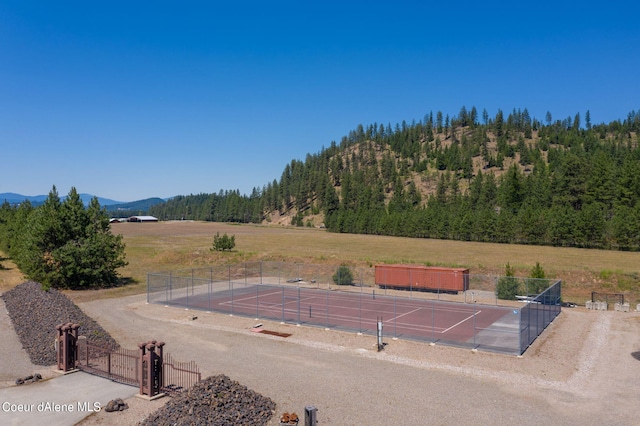 exterior space with fence, a mountain view, a wooded view, and a rural view