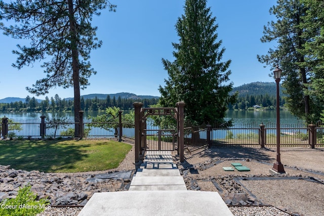 view of community featuring a gate, fence, and a water and mountain view