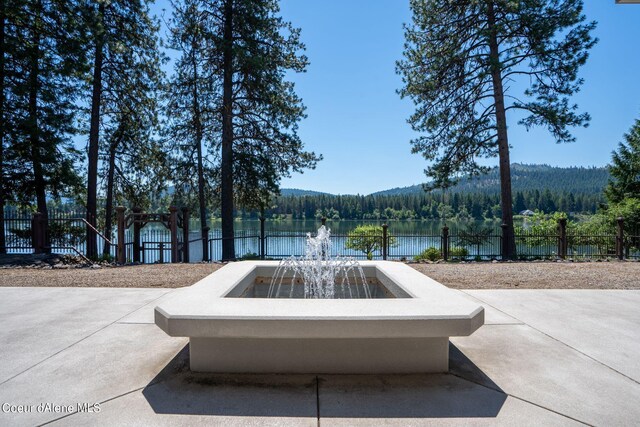 view of home's community featuring a water view, fence, and a view of trees