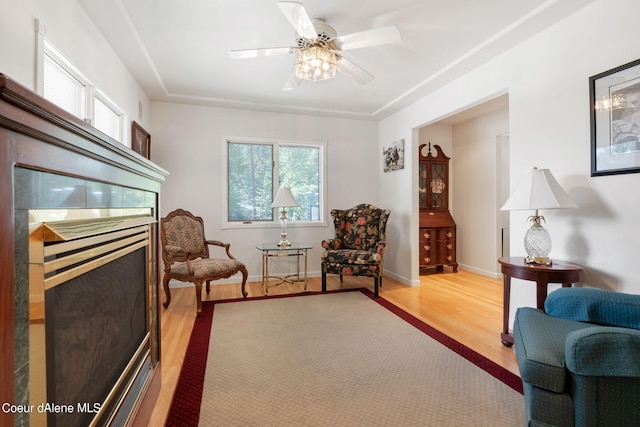 living area featuring baseboards, a ceiling fan, and light wood-style floors