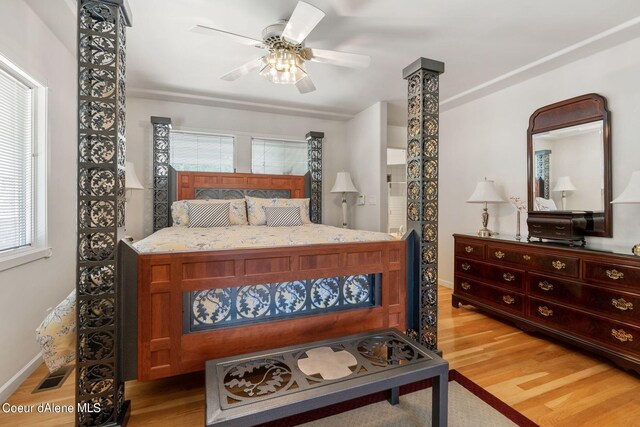 bedroom with a ceiling fan, visible vents, light wood-style flooring, and baseboards