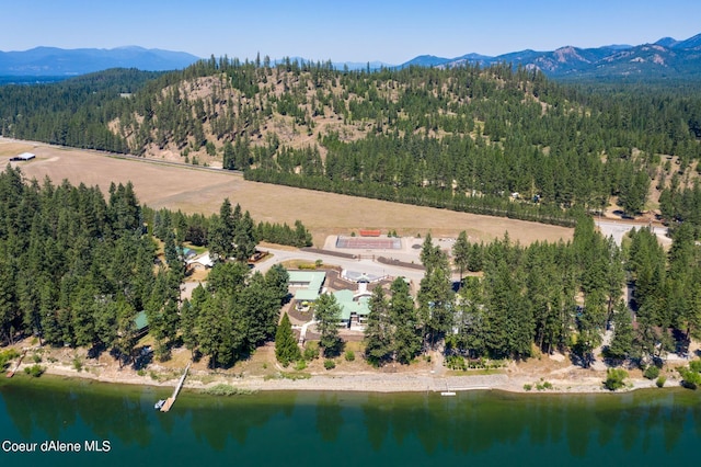 aerial view featuring a forest view and a water and mountain view