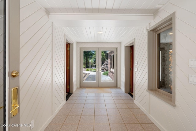 doorway featuring wooden walls, french doors, and light tile patterned flooring